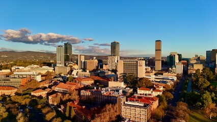 Adelaide CBD, South Australia, June 21, 2025: Aerial Sunset Drone Image Showing Modern Skyline of the City, Skyscrapers, University of Adelaide Campus, Parklands, and Urban Landscape in Golden Light