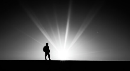 Silhouette of a person standing at sunrise