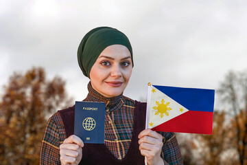 Muslim Woman Holding Passport and Flag of Philippines 
