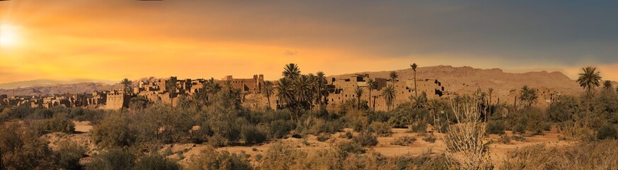 Saharan village,  ruined buildings, snowy mountains.
