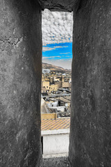 Cityscape viewed through a narrow tower opening.