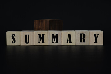 Wooden Blocks Spelling 'SUMMARY' on Reflective Surface With Small Plant. Wooden Blocks Displaying...
