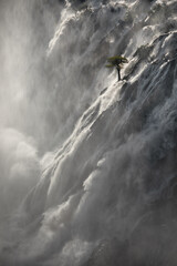 A tree stands against the torrents of water cascading over Ruacana Falls, Namibia.