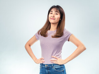 Confident Asian woman standing with hands on hips, smiling with pride and satisfaction, wearing a...