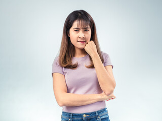 Asian woman in purple t-shirt and jeans looking to the side with thoughtful expression, hand...