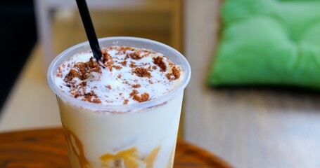 Velvety cream swirling over cold coffee, dusted with chocolate cookie crumbles, highlighting luxurious summer drink experience