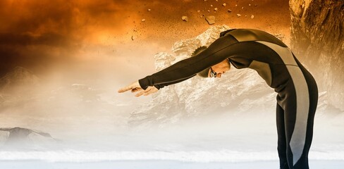 Male swimmer diving against rock formations during sunset