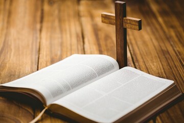 Bible and wooden cross on floor