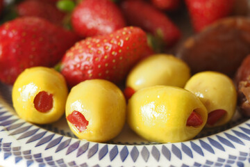 Colorful fruit and stuffed olives displayed on a plate