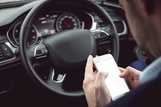 Fototapeta Man driver using smart phone in car