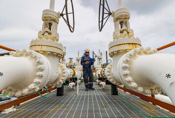 Male worker inspection at steel long pipes and pipe elbow in station oil factory during refinery...