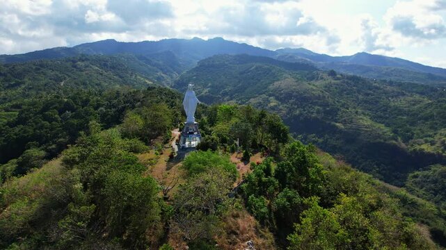 Aerial drone shot of Nilo viewpoint, with a white Mary statue, on top of all the city of Maumere, Flores island, Indonesia