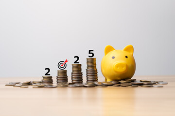 Yellow piggy bank with stacked coins and number 2025, symbolizing saving money, financial investment, business growth, wealth building, budgeting goals, future economic planning for the year 2025