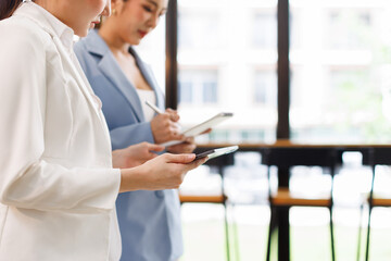 Two Young Asian Happy business women standing and holding tablet in hand confidence leadership in a...