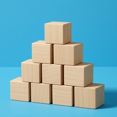 Fototapeta premium Stacked wooden blocks form a pyramid on blue background