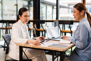 Team of confident business people point to graphs and charts to analyze market data, balance sheet, account, net profit to plan new sales strategies to increase production capacity.	