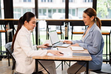 Team of confident business people point to graphs and charts to analyze market data, balance sheet, account, net profit to plan new sales strategies to increase production capacity.	