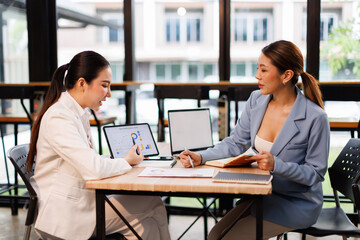 Team of confident business people point to graphs and charts to analyze market data, balance sheet, account, net profit to plan new sales strategies to increase production capacity.	