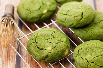 Chewy matcha chocolate chip cookies on cooling rack.