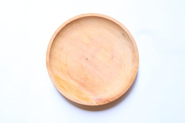 Top view of an empty round wooden plate on a white background