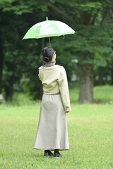 雨傘を持って微笑む日本人の若い女性