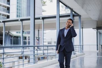 Businessman walking and talking on phone in modern office building