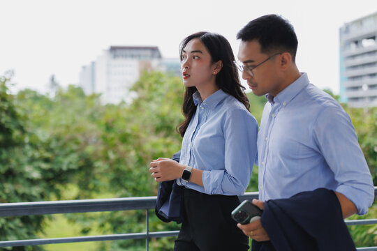 Business colleagues walking and talking on balcony with city view