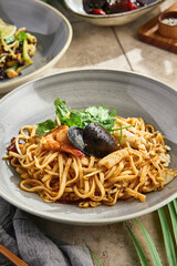 Seafood wok-fried noodles in bright natural light, overhead rustic composition