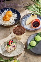 Meringue roulade, sesame mochi, cheesecake, tiramisu, fried ice cream, bright rustic overhead composition