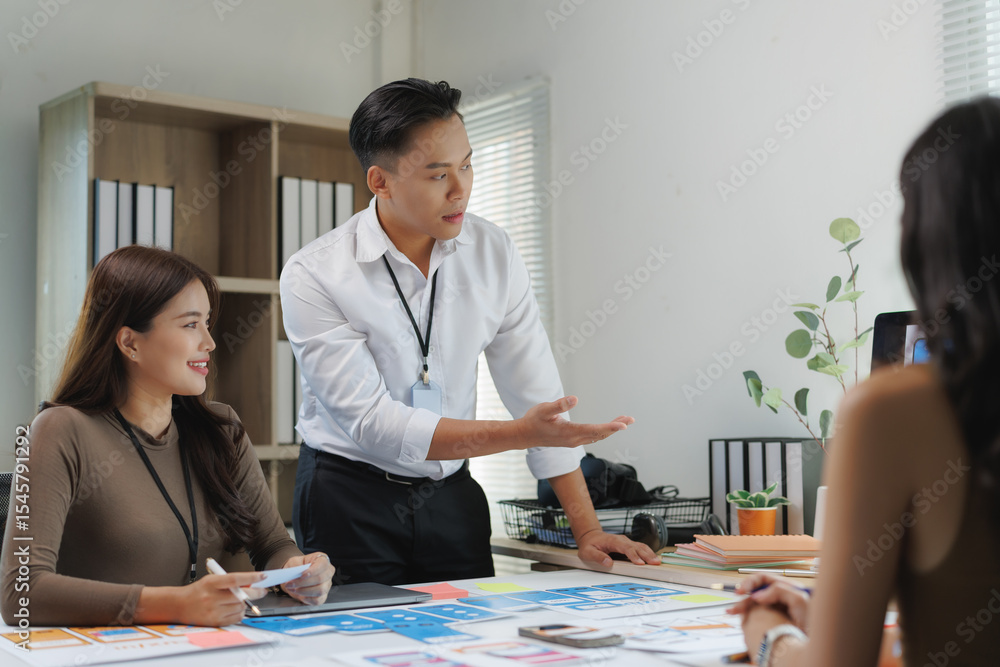 Aufkleber asian uiux developers discussing mobile app design during meeting