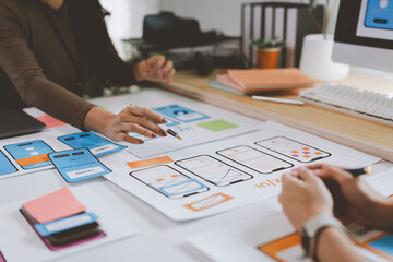 Ux designers working on mobile app wireframe in office