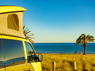 Camper van with tent on roof on beach