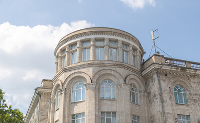 Obraz premium A building with a round roof, white windows, and columns on each side.