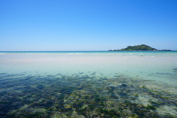 clear shoaling beach and far island