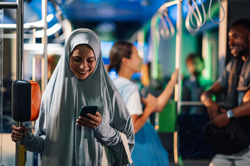 Muslim woman using smartphone on public transport bus
