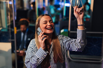 Cheerful businesswoman talking on phone while riding bus