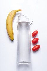 Hydration and healthy snacking with a sports water bottle, fresh cherry tomatoes, and a ripe banana, representing balanced nutrition, energy, and wellness on the go.