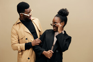 Stylish young couple playfully interacting, showcasing modern fashion in neutral colors,...