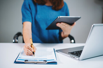 business documents on office table with smart phone and digital tablet and graph financial and...