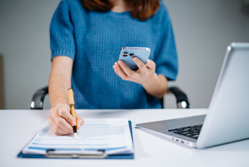 business documents on office table with smart phone and digital tablet and graph financial and...