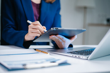 Obraz premium usiness woman sitting front tablet ,laptop computer with financial graphs and statistics