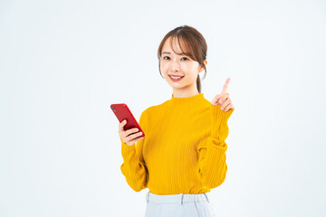 スマホを持っておすすめするカジュアルウェアの女性