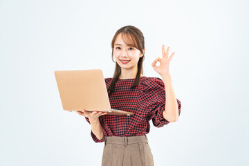 PCを持ってOKサインを見せるカジュアルウェアの女性