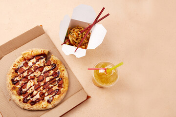 A tempting round pizza topped with cheese and slices of pepperoni sits next to a takeout container...