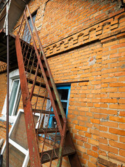 A fire escape ladder leaning against a brick wall