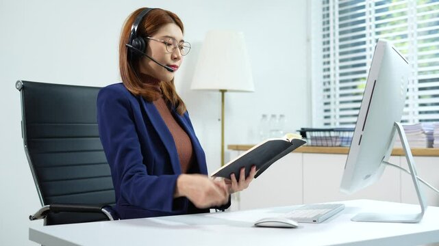 Friendly smiling female call-center agent with headset working on support hotline in office.