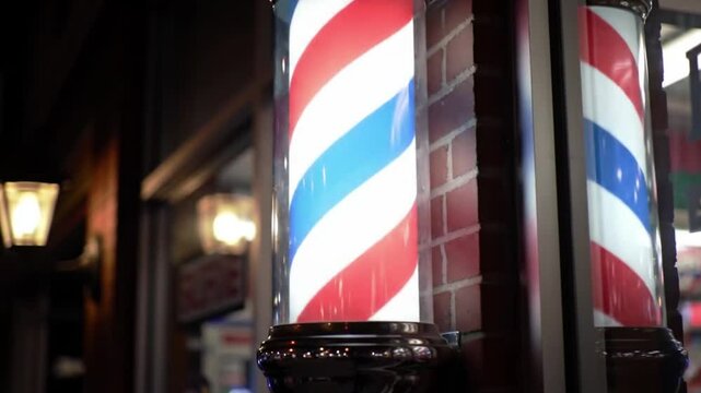 Two classic red white and blue barber poles. Suitable for barber shops, hair salons, vintage themes, patriotic designs, and Americana concepts.