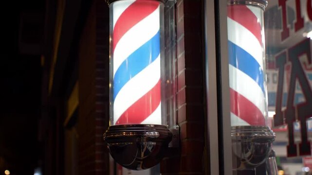 Two classic red white and blue barber poles. Suitable for barber shops, hair salons, vintage themes, patriotic designs, and Americana concepts.