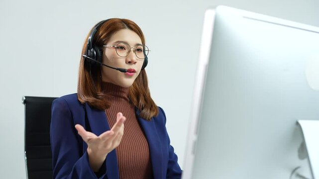 Friendly smiling female call-center agent with headset working on support hotline in office.