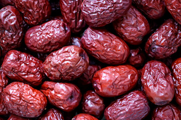 Macro shot of a pile of dried red jujubes.